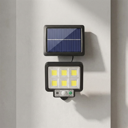 Solar-powered outdoor light fixture attached to a wall