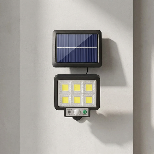Solar-powered outdoor light fixture attached to a wall